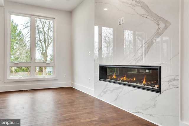 unfurnished living room featuring a fireplace and dark hardwood / wood-style floors