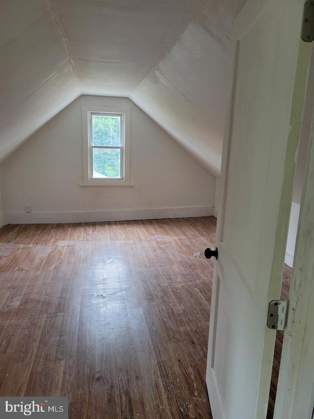 bonus room with wood-type flooring and vaulted ceiling