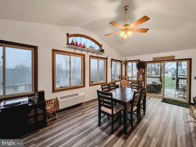 dining space with hardwood / wood-style flooring, vaulted ceiling, a wall mounted AC, and ceiling fan