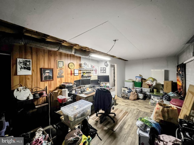 home office with wood-type flooring and wooden walls