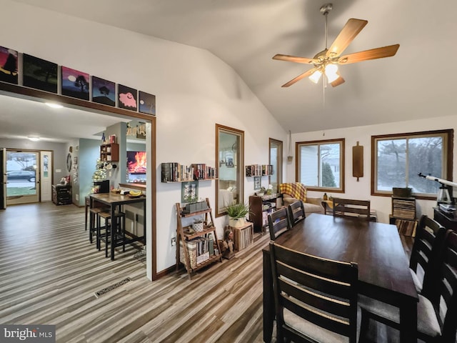 dining space featuring ceiling fan, lofted ceiling, and hardwood / wood-style flooring