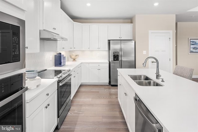 kitchen with white cabinets, light wood-type flooring, sink, and appliances with stainless steel finishes