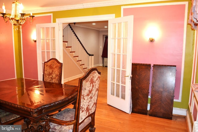 dining area with baseboards, stairs, ornamental molding, wood finished floors, and a notable chandelier