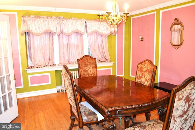 dining area with radiator, baseboards, a chandelier, ornamental molding, and wood finished floors