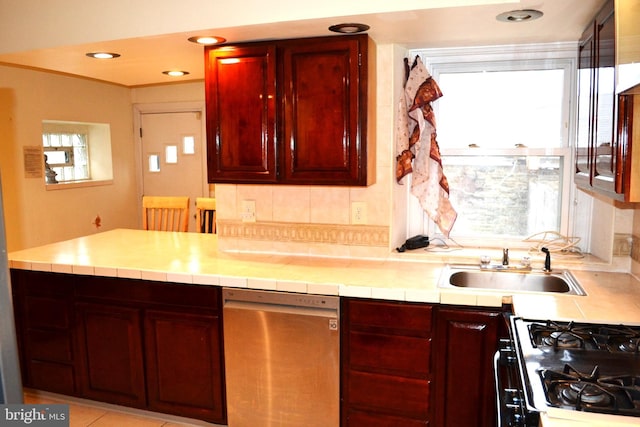 kitchen with dark brown cabinets, gas range, recessed lighting, stainless steel dishwasher, and a sink