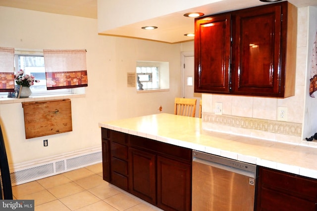 kitchen with tasteful backsplash, reddish brown cabinets, a peninsula, light tile patterned flooring, and dishwasher