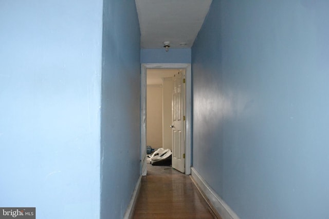 hall with baseboards and dark wood-style flooring