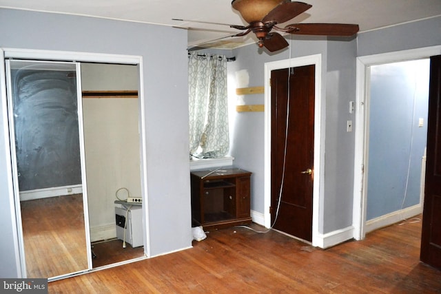 unfurnished bedroom featuring ceiling fan, baseboards, and wood finished floors