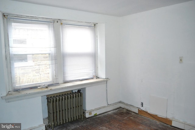 empty room with radiator and wood finished floors