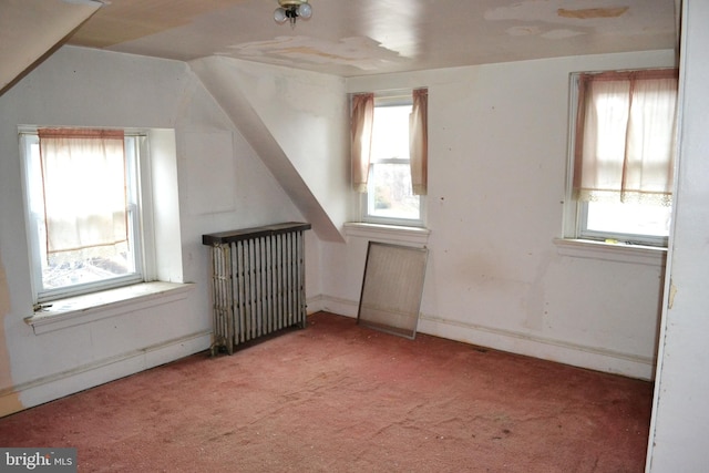 additional living space with a wealth of natural light, carpet floors, radiator, and lofted ceiling