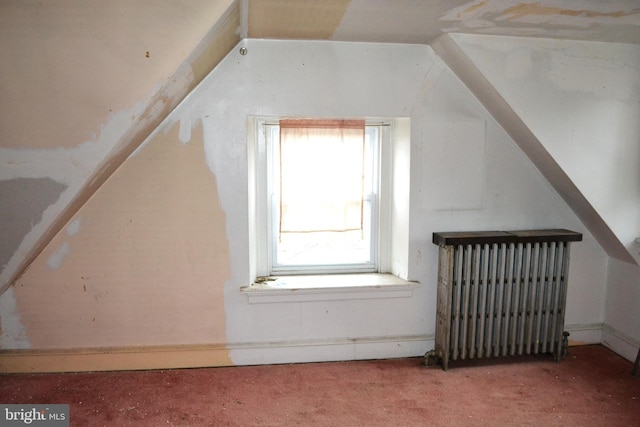 bonus room with vaulted ceiling, radiator, and carpet