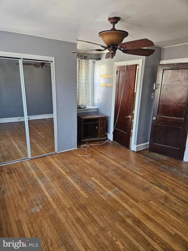 unfurnished bedroom with hardwood / wood-style floors, baseboards, and ceiling fan