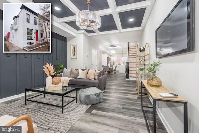 living room featuring coffered ceiling, beamed ceiling, crown molding, a chandelier, and wood-type flooring