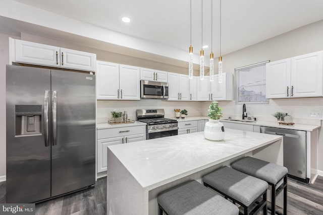 kitchen with dark hardwood / wood-style floors, a kitchen island, white cabinetry, and stainless steel appliances