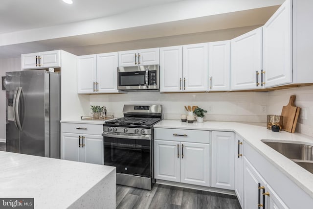 kitchen with white cabinets, stainless steel appliances, and dark hardwood / wood-style floors