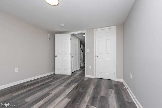 unfurnished bedroom featuring a closet and dark hardwood / wood-style floors