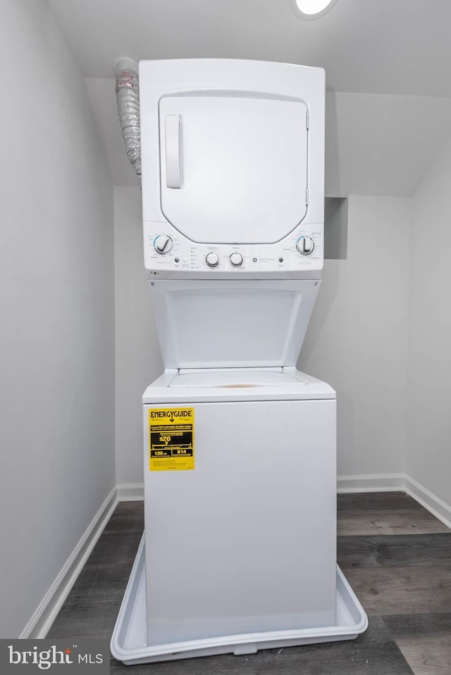 laundry area with dark hardwood / wood-style flooring and stacked washing maching and dryer