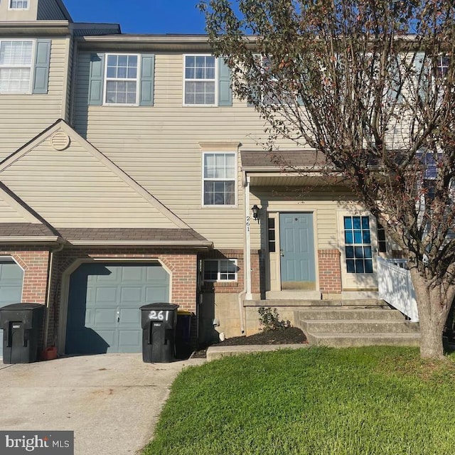 townhome / multi-family property featuring a garage and a front yard