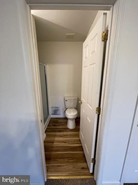 bathroom with hardwood / wood-style flooring and toilet