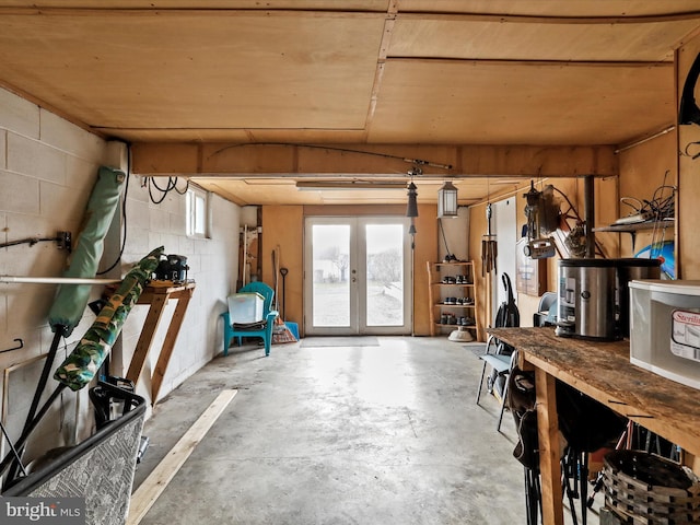 interior space featuring a workshop area, french doors, and concrete floors