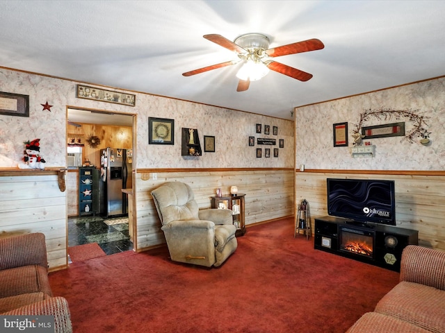 carpeted living room featuring ceiling fan, ornamental molding, and a fireplace