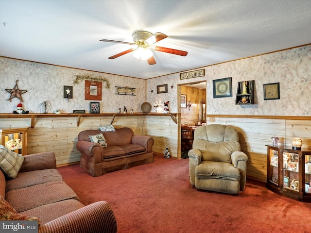 carpeted living room with ceiling fan, crown molding, and a textured ceiling