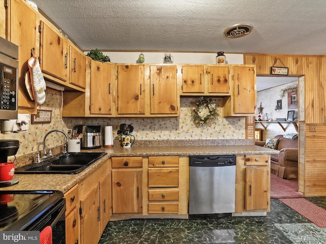 kitchen with a textured ceiling, stainless steel appliances, and sink