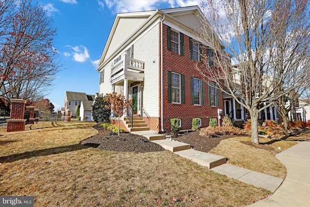 view of side of property with a lawn and a balcony