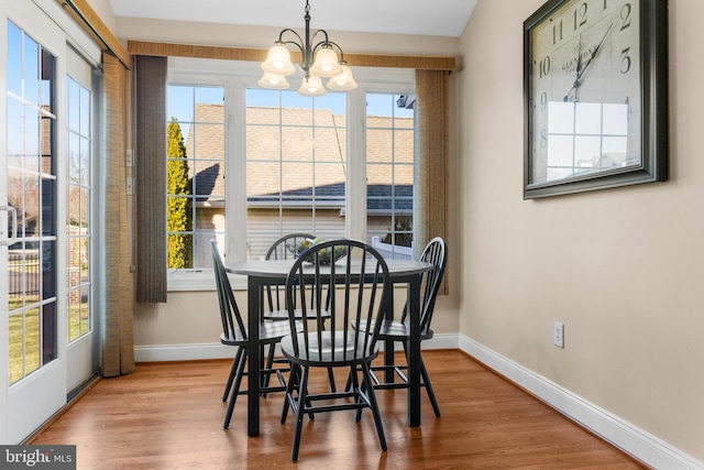 dining space with a wealth of natural light, light hardwood / wood-style flooring, and a chandelier