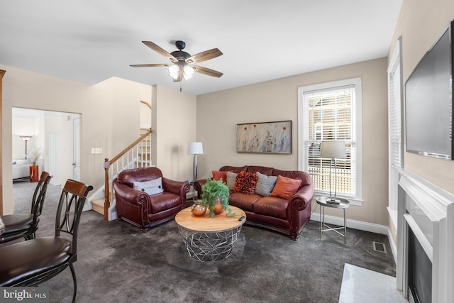 carpeted living room with ceiling fan