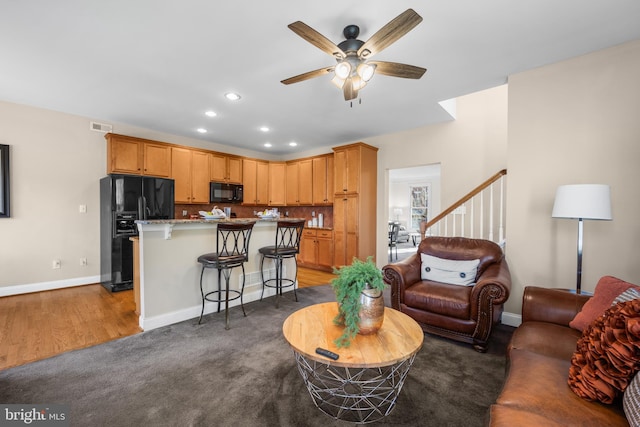 living room with ceiling fan and dark carpet