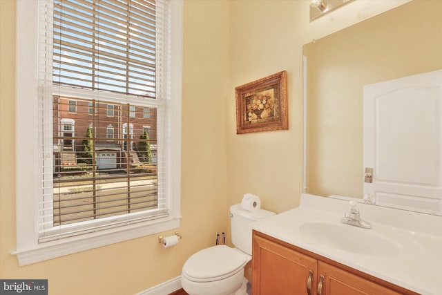 bathroom with plenty of natural light, vanity, and toilet