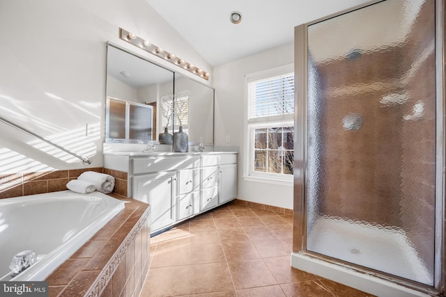 bathroom featuring tile patterned flooring, vanity, separate shower and tub, and vaulted ceiling