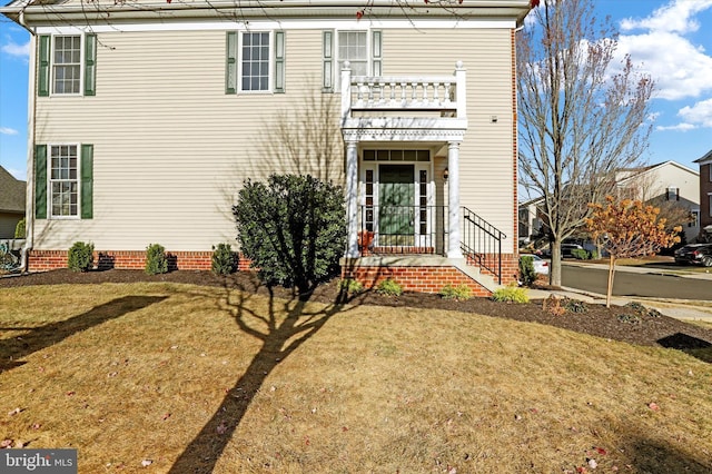 view of front of property with a balcony and a front yard