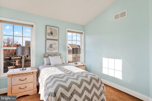 bedroom with light colored carpet, multiple windows, and lofted ceiling