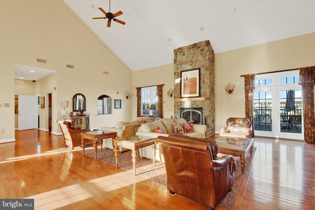 living room featuring a wealth of natural light, high vaulted ceiling, and light wood-type flooring