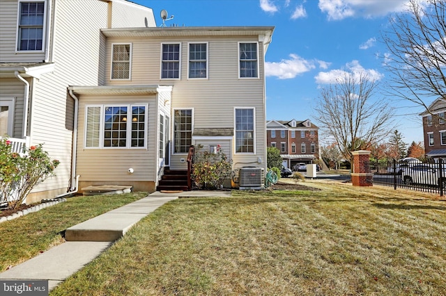 view of front of house featuring central AC unit and a front yard