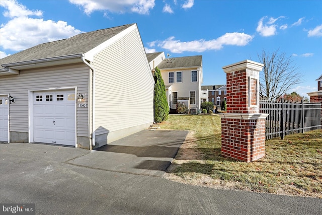 view of side of home featuring a garage and a lawn