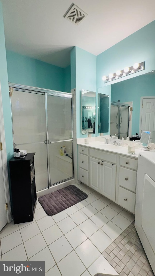 bathroom featuring tile patterned flooring, vanity, and a shower with shower door