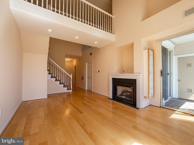 unfurnished living room with a high ceiling and hardwood / wood-style flooring