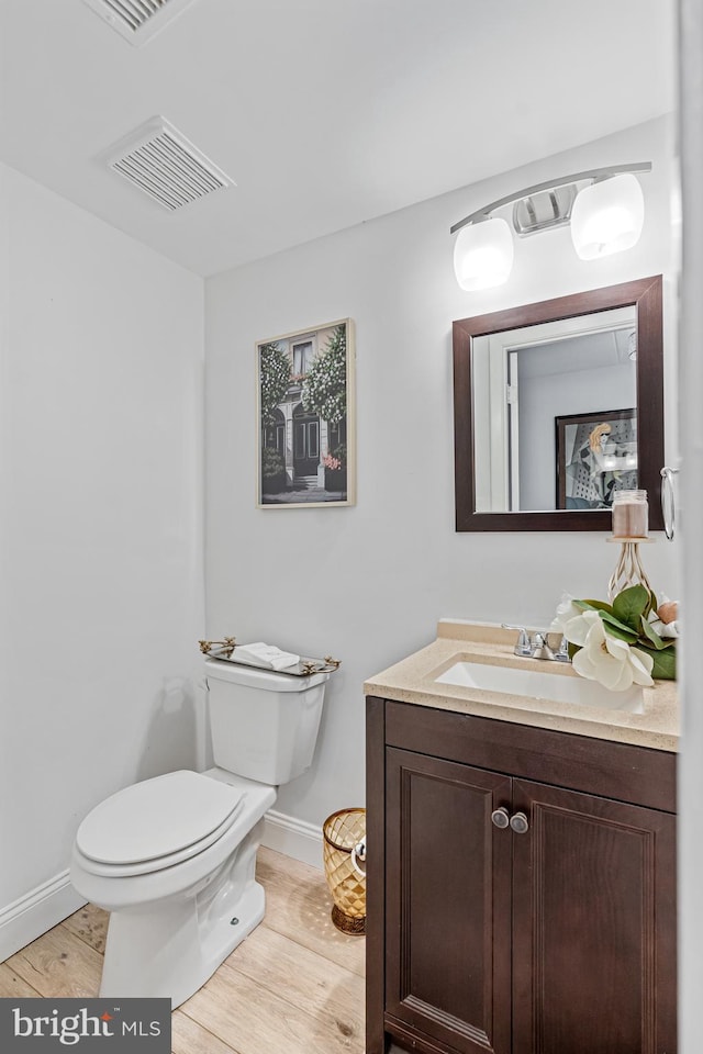 bathroom featuring vanity, toilet, and wood-type flooring