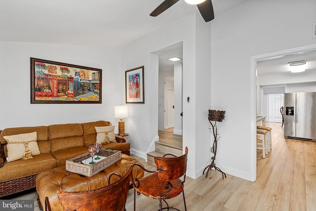 living room featuring ceiling fan, light wood-type flooring, and lofted ceiling