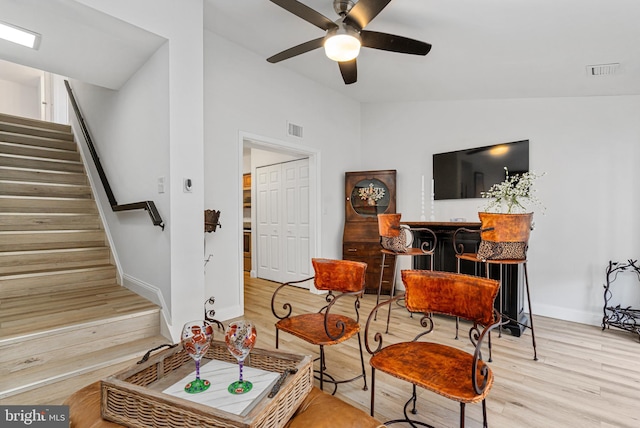 sitting room with ceiling fan, light hardwood / wood-style flooring, and vaulted ceiling