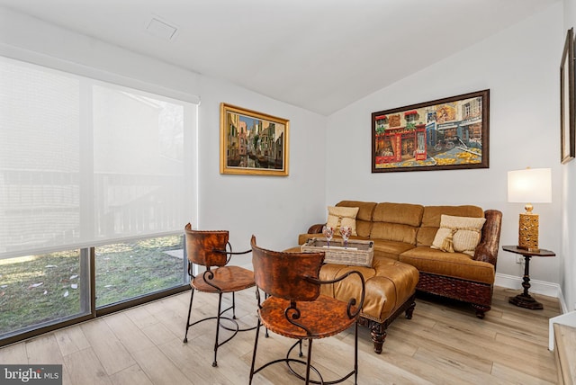 living room with light hardwood / wood-style floors and lofted ceiling