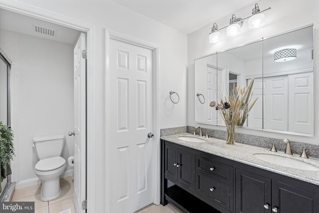 bathroom featuring tile patterned floors, vanity, toilet, and a shower with shower door