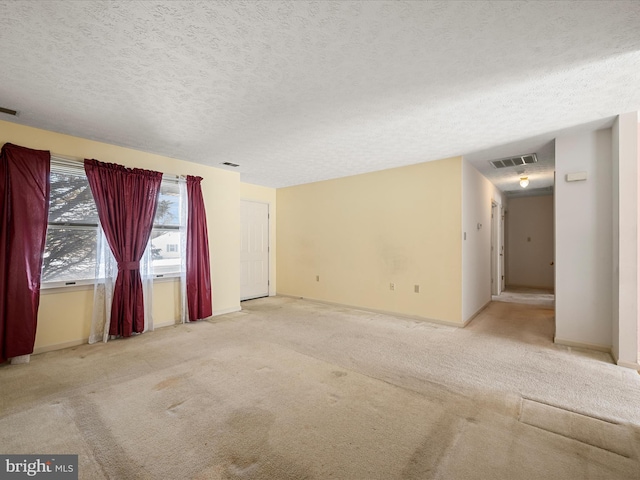 carpeted empty room with a textured ceiling