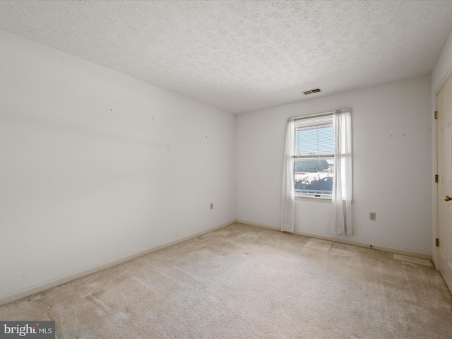 carpeted spare room with a textured ceiling