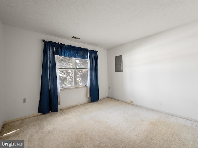 carpeted empty room with electric panel and a textured ceiling