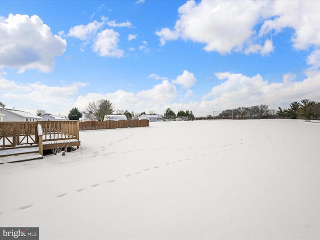 yard covered in snow with a wooden deck