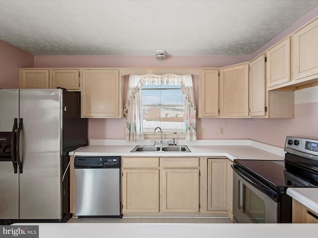 kitchen featuring sink, light brown cabinets, a textured ceiling, and appliances with stainless steel finishes